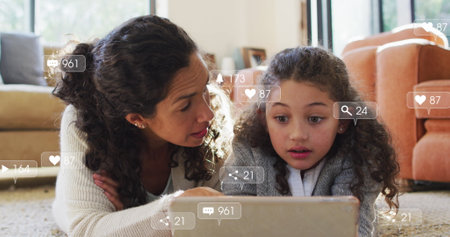 Lying mother and daughter scrolling tablet on living room carpet, with floating social media icons....