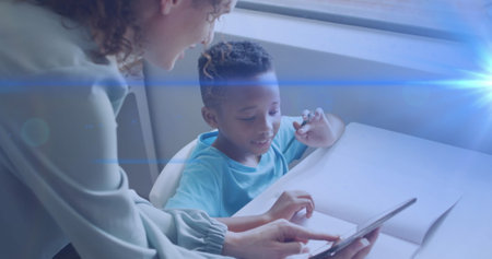 Image of light trails over diverse schoolboy and teacher using tablet. Global education and learning...