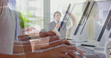 Image of hands using laptop over diverse business people in office. Global business and digital interface concept digitally generated image.の写真素材