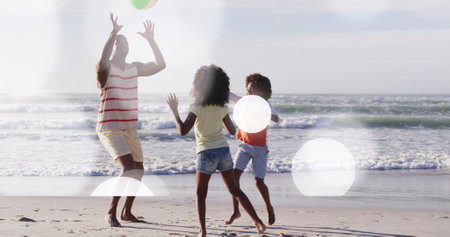 Image of light spots over african american family at beach. Lifestyle and free time concept digitally generated image.の写真素材