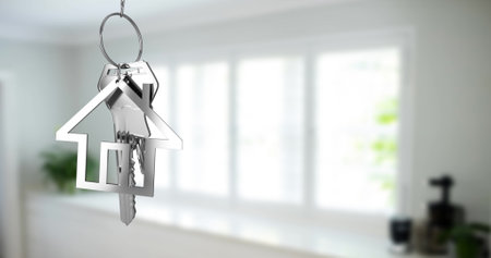 Image of key with keychain in shape of house over kitchen interior. Moving house concept digitally generated image.の写真素材