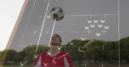 Soccer player in red jersey preparing to head soccer ball in grassy field with tactical overlay. Athlete, sports, strategy, outdoor, athleticism, competition, trainingの写真素材