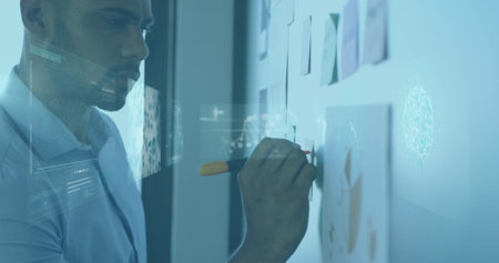 Image of infographic interface, dna helix over african american man writing on board in office. Digital composite, multiple exposure, molecule, genetic, reports, data, business and technology.の写真素材