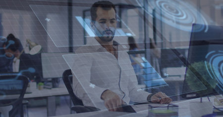 Interacting bearded man in white shirt using floating digital panels at open-plan office, tech hub....