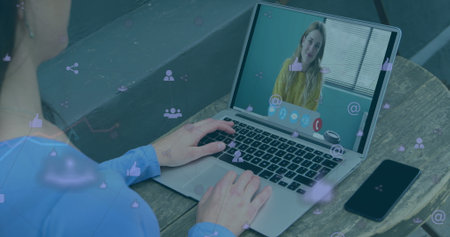 Typing man in blue shirt joining online call at home workspace with laptop, smartphone, coffee cup. Technology, communication, remote, modern, collaboration, workspace, productivityの写真素材
