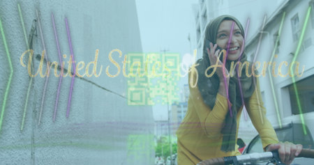 Talking woman in olive headscarf, mustard top riding bicycle at street, with smartphone, copy space. Urban, transportation, technology, streetwear, modern, lifestyle, cityscapeの写真素材