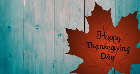 Showing brown maple leaf silhouette displaying Happy Thanksgiving Day text on teal wall, copy space. Autumn, rustic, foliage, harvest, nature, celebration, seasonalの写真素材