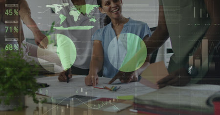 Four businesswomen collaborating over printed charts at conference table, with pencils and overlays....