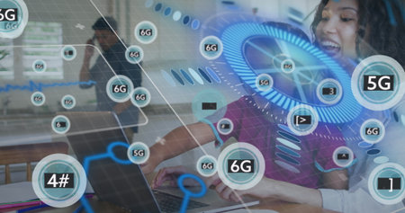 Typing curly-haired woman leaning over laptop at office desk, digital network graphics, copy space. Collaboration, innovation, teamwork, modern, technology, digital, workspaceの写真素材