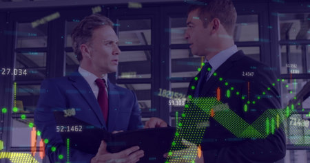 Reviewing two men in suits using digital tablet in server room, with hologram financial charts....