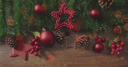 Displaying Christmas decor on wood table with red baubles, pine branches and star cookie cutter. Festive, natural, cozy, rustic, holiday, decorative, seasonalの写真素材