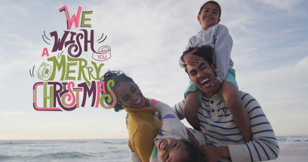 Laughing parents holding children on sandy beach, with Christmas graphic overlay, copy space. Family, celebration, outdoor, joyful, vacation, vibrant, leisureの写真素材