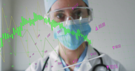 Standing doctor wearing surgical gear and stethoscope, studying green-yellow line charts in clinic....