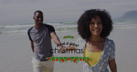 Walking couple holding hands along sandy shore under cloudy sky, with holiday greeting graphic. Romance, seaside, leisure, serenity, celebration, connection, minimalistの写真素材