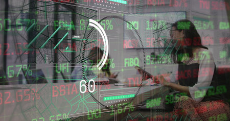 Holding tablet and speaking woman wearing smart casual in meeting room, with stock market display....