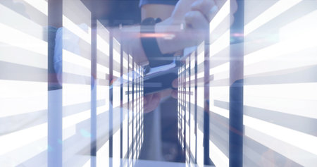 Gripping smartphone, person in dark sportswear leaning on support bar at tech lab, with LED panels. Futuristic, technology, illumination, modern, innovation, industrial, sleekの写真素材