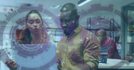 Woman and man coworkers examining document at wooden desk in open-plan office, with digital overlay. Collaboration, teamwork, coworking, digital interface, modern workspace, productivity, professionalの写真素材