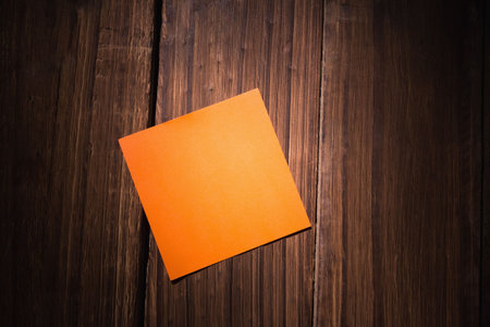 High angle view of orange blank adhesive note on wooden table, copy space. Unaltered, reminder,...