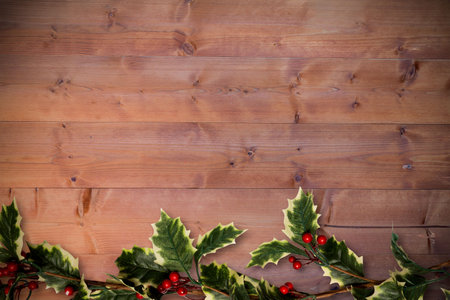 Holly twigs over wooden planks with copy spaceの写真素材