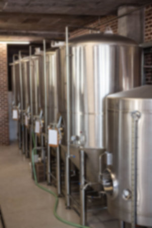 Defocused image of distillery storage tank arranged in row at factory
