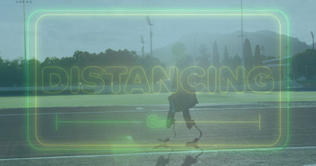 Sprinting boy with prosthetic blades on track lanes at stadium, floodlight poles, neon DISTANCING. Athlete, competition, motion, agility, outdoor, endurance, speedの写真素材