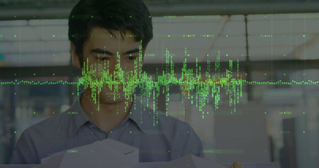 Native American in gray shirt handling cardboard boxes in warehouse, with green digital waveform....