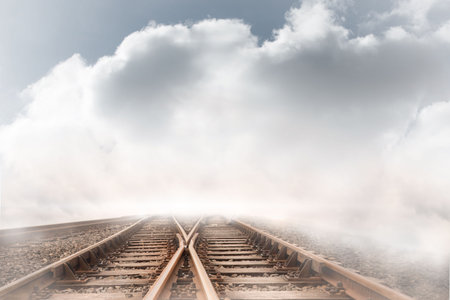 Train tracks leading over the cloudy horizon