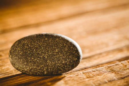 Close-up of stone balanced on wooden tableの写真素材