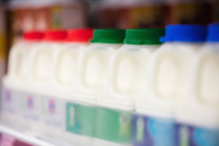 Milk bottles for sale on shelf at supermarket