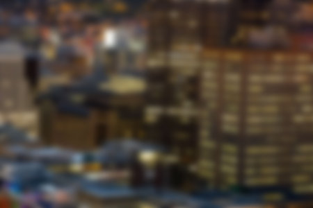 Defocused image of illuminated crowded buildings at nightの写真素材