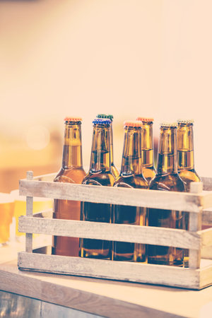 Beer bottles in wooden crate on tableの写真素材