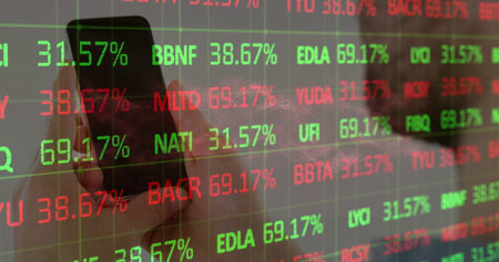 Holding smartphone with left hand in office, displaying stock data on transparent panel, copy space....