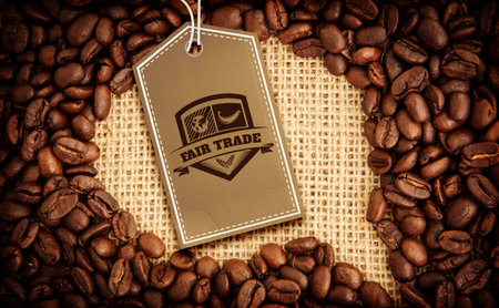 Quality tag over speech bubble surrounded by coffee beans on textileの写真素材
