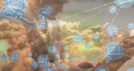 Leaning forward man in casual tee interacting with smartphone in cloud network, floating icons. Technology, connectivity, innovation, communication, digital, futuristic, businessの写真素材