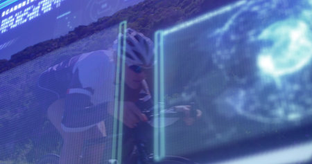 Pedaling cyclist wearing helmet and suit on road bike on hillside road, with digital display....