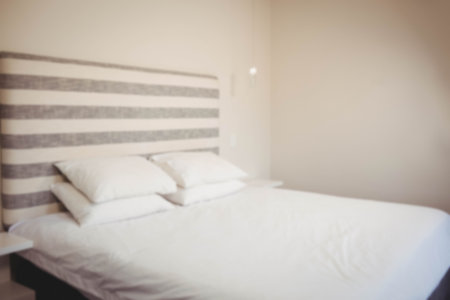 Bed against wall in bedroom at homeの写真素材