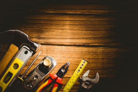 Flat design showing hand tools aligning left on wooden workbench with warm lighting, showing grain....
