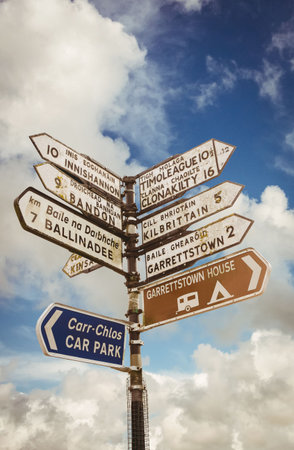 Low angle view of sign posts against cloudy skyの写真素材