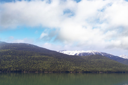Idyllic view of mountains by river against skyの写真素材