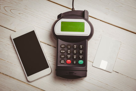 Showing flat design overhead view of phone, payment terminal and credit card on whitewashed table....