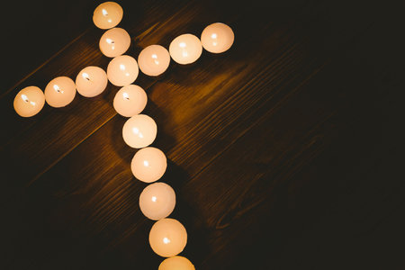 Candles in shape of cross on wooden tableの写真素材