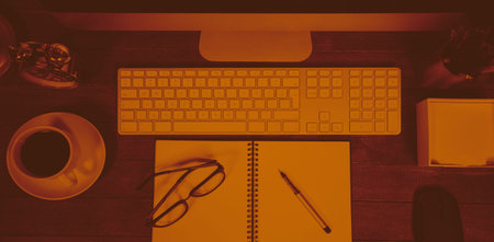 Overhead of coffee, spectacles and office supplies on deskの写真素材