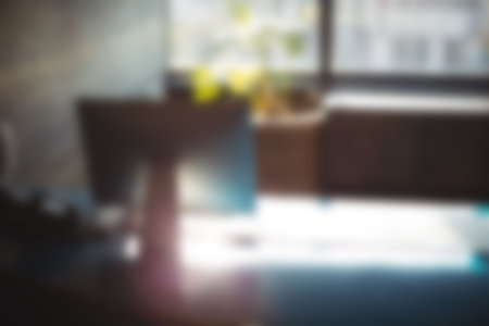 Defocused image of desktop pc on table in office