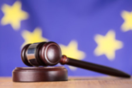 Close-up of gavel on desk against European Union flagの写真素材