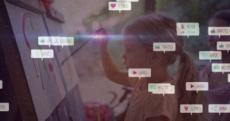 Two school-age girls painting colorful strokes at easels in home art corner, with reaction icons. Creative, education, trend, vibrant, collaboration, inspiration, playfulの写真素材