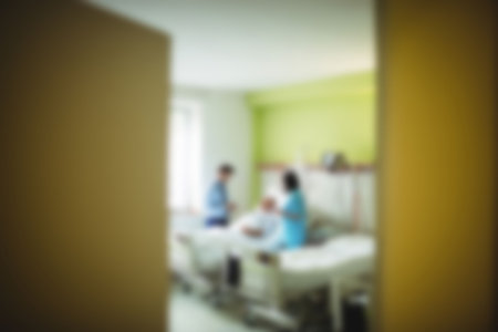 Blurry view of doctor taking care of patient in hospital roomの写真素材
