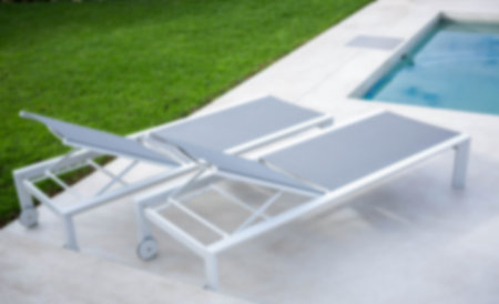 High angle view of empty lounge chairs by swimming pool in yard