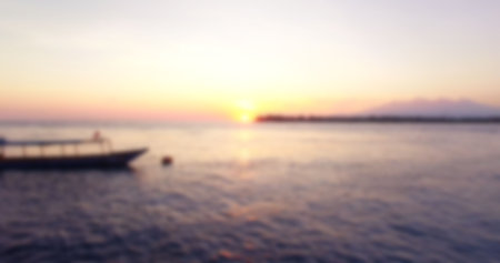Defocused image of seascape against sky during sunsetの写真素材