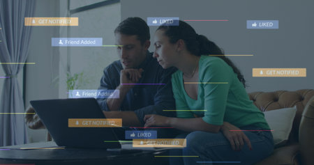 Sitting couple leaning toward laptop on coffee table near sofa at home, with notification graphics....