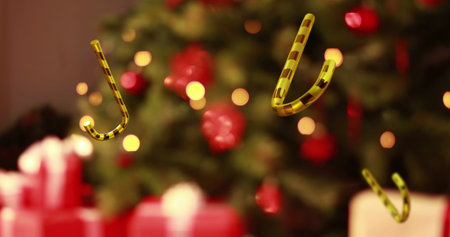 Gold-black candy cane ornaments floating in living room, tree with baubles, lights, gift boxes. Festive, holiday, celebration, decorative, seasonal, warm, cozyの写真素材